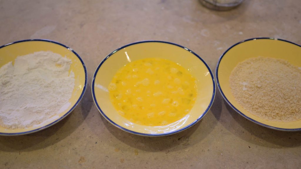 Three bowls set up to dredge and batter artichokes