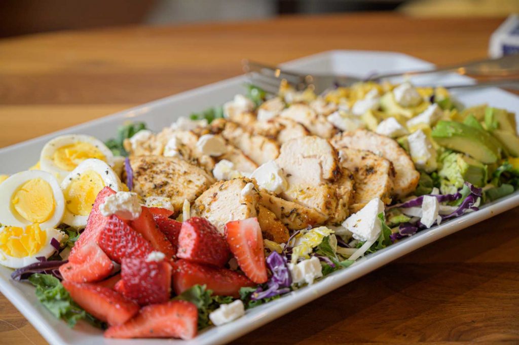 Kale Salad with Air Fryer Herb Chicken on a Rectangular Serving Plate