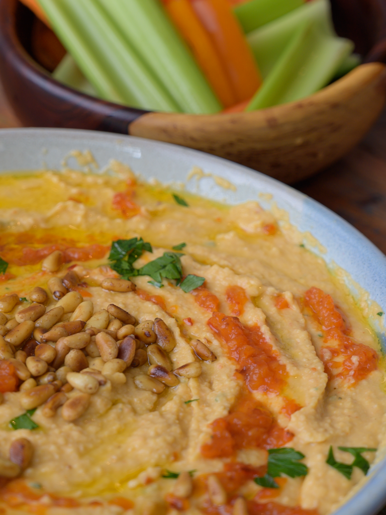 Red Pepper Hummus in a Bowl with Toasted Pine Nuts and Parsley