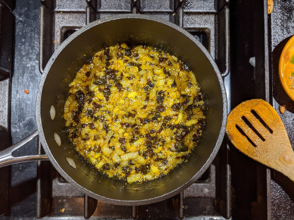 Onions, garlic, lemon zest, currants and spices sauteeing in olive oil